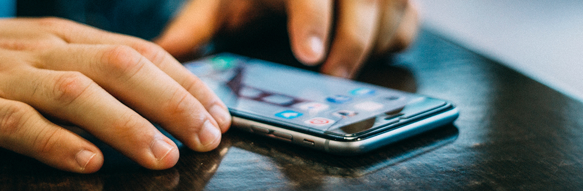 Close up of someone using a smart phone on a desk