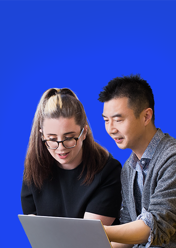 One male and one female Jade employee working together on a laptop