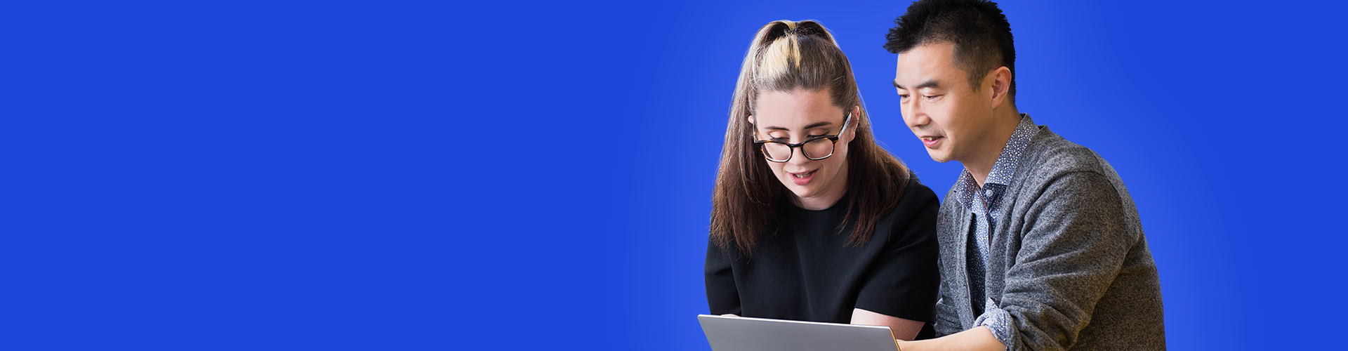 One male and one female Jade employee working together on a laptop