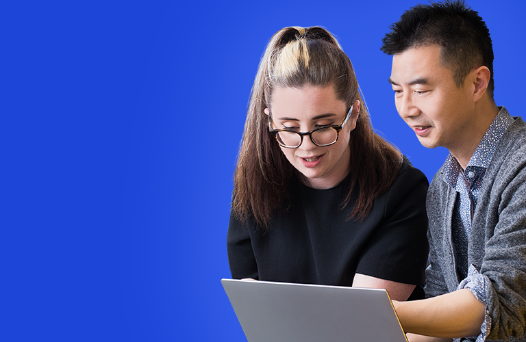 One male and one female Jade employee working together on a laptop