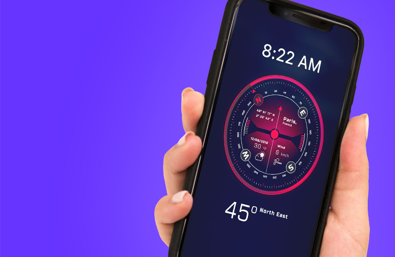 A lady's hand holding a mobile phone that has a compass and the time displayed on it