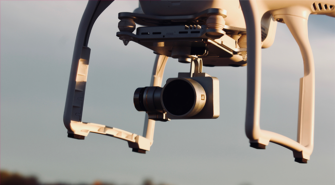 A drone in the air with a camera attached to it